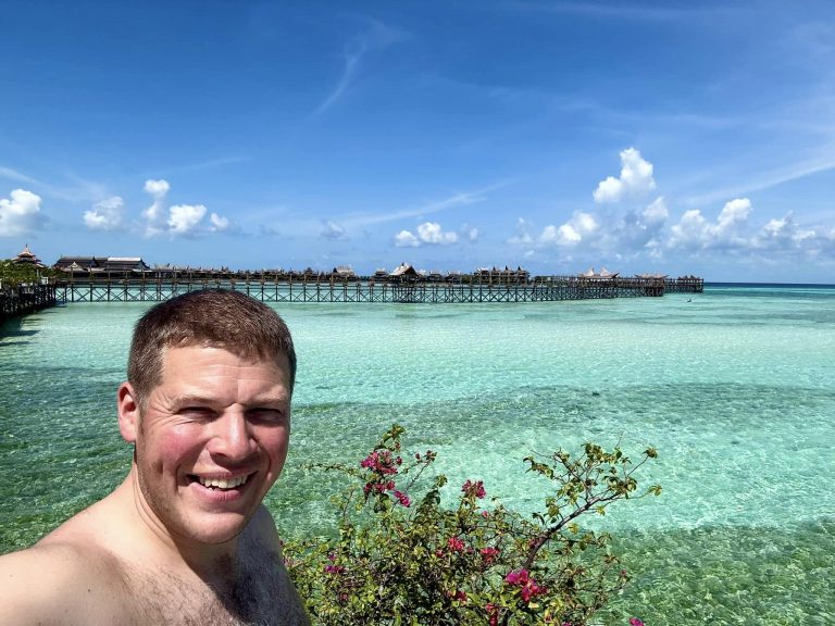 Rick Parker (Underwater Parker) overlooking the Sipadan Mabul Resort water bungalows with crystal-clear sea, Malaysia