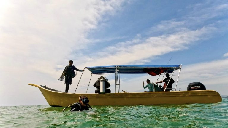 Scuba Divers at Langkawi Island about to back roll from the boat